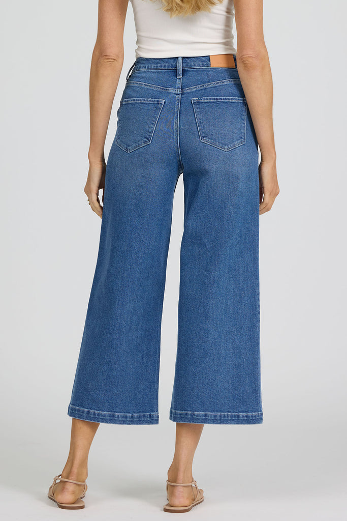 woman wearing blue jeans against a white background