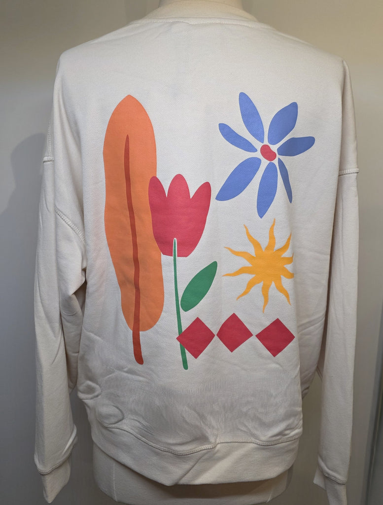 White sweatshirt with colorful abstract designs on a plain background