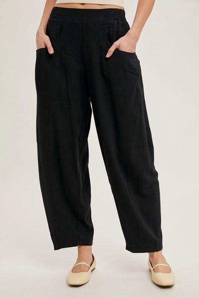 black barrel pants with hands in pocket against white background