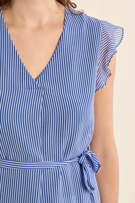 Blue and white striped dress with ruffled sleeves on a beige background