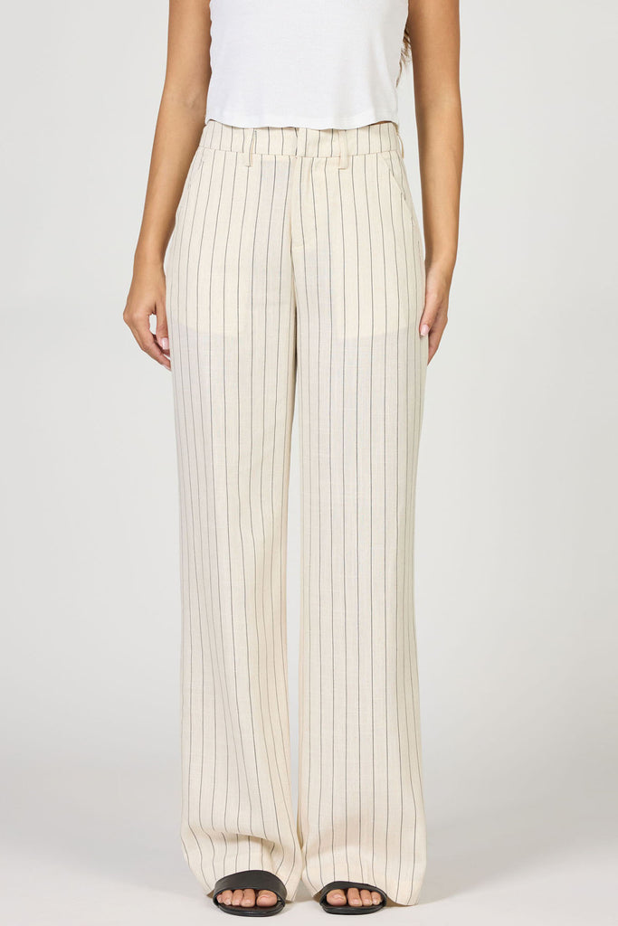 Person wearing white pleated pants on a plain background