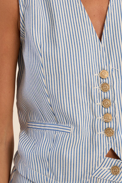 Close-up of a blue and white striped sleeveless top with decorative buttons.