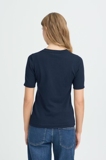 Person wearing a navy blue t-shirt and blue jeans on a white background