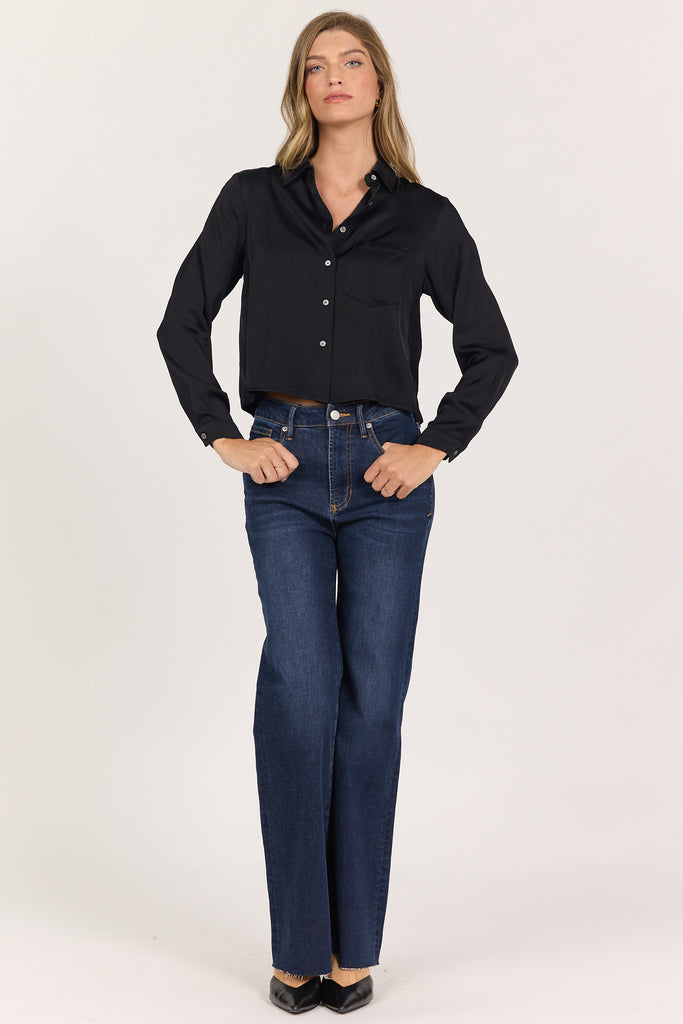 woman in black, cropped button up blouse and jeans