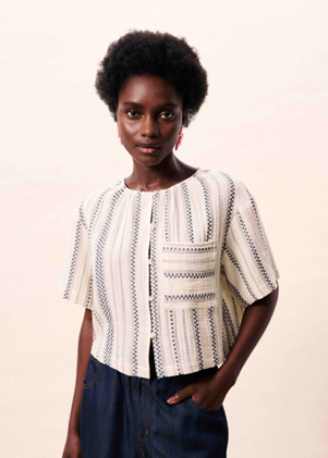 Woman wearing a patterned blouse against a plain background