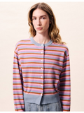 Woman wearing a colorful striped sweater against a plain background