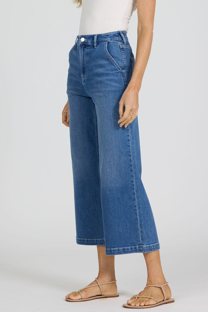 woman wearing blue jeans against a white background