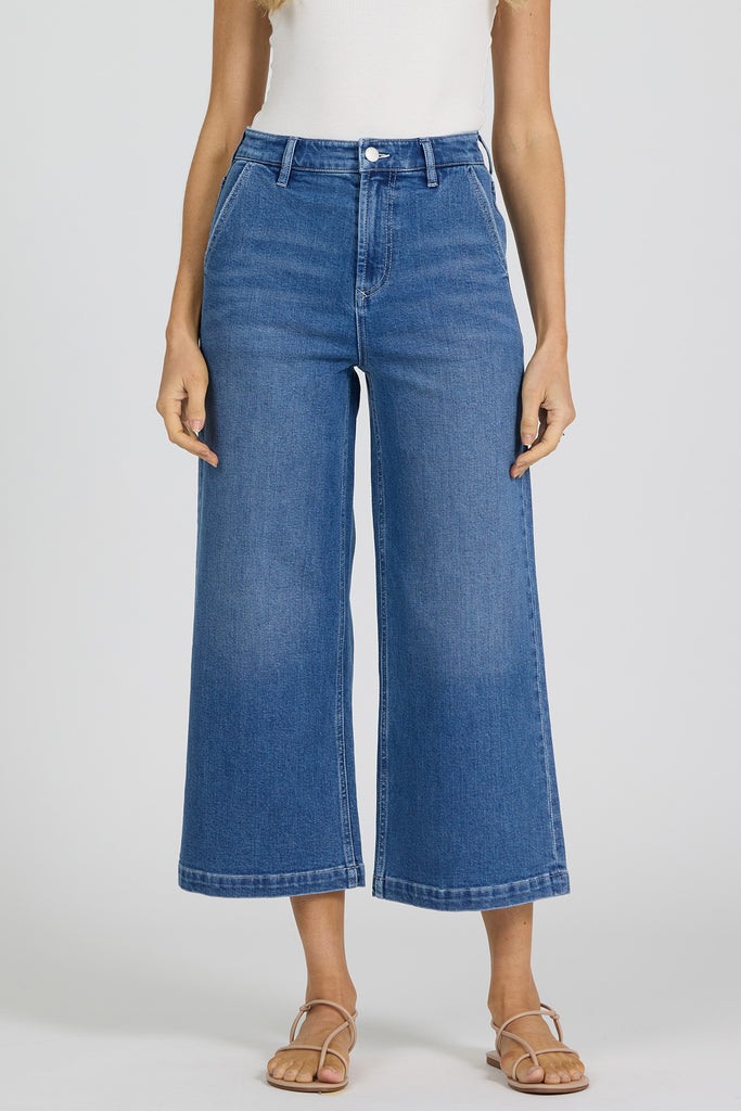 woman wearing blue jeans against a white background