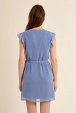 Woman wearing a blue and white striped dress on a beige background