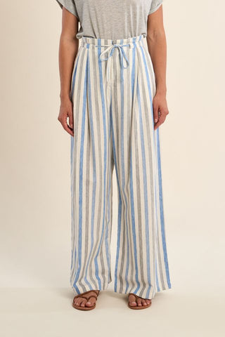 Person wearing blue and beige striped pants on a beige background