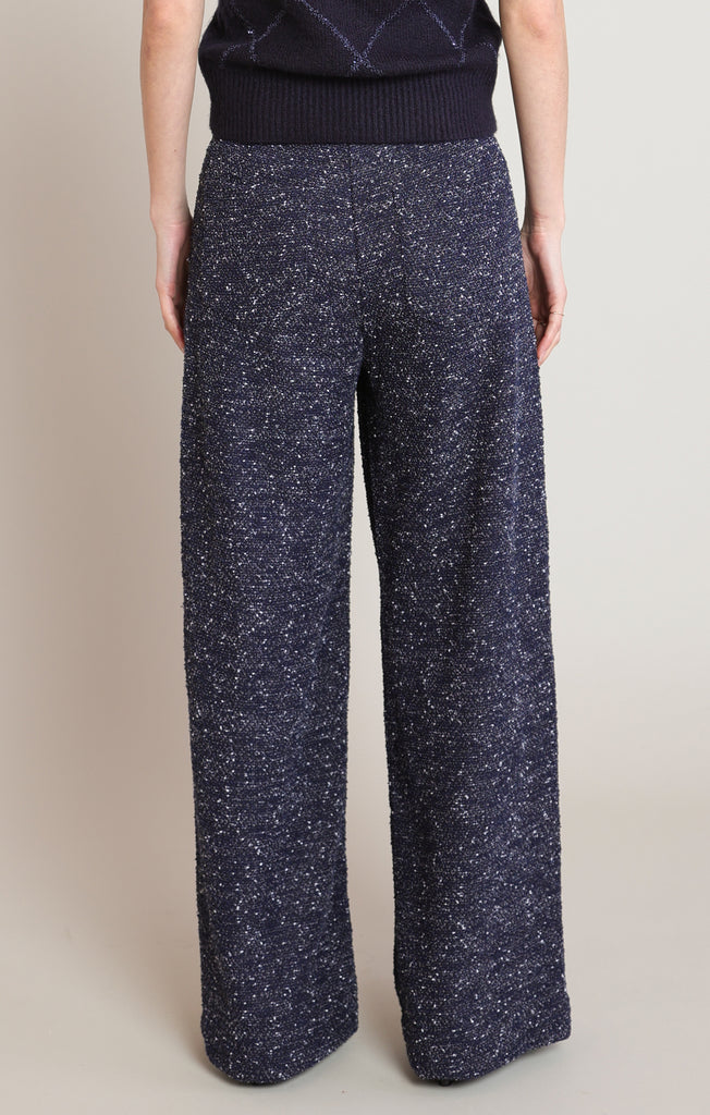 Navy blue patterned pants worn by a person on a beige background