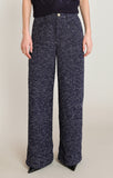 Person wearing navy blue patterned pants on a plain background