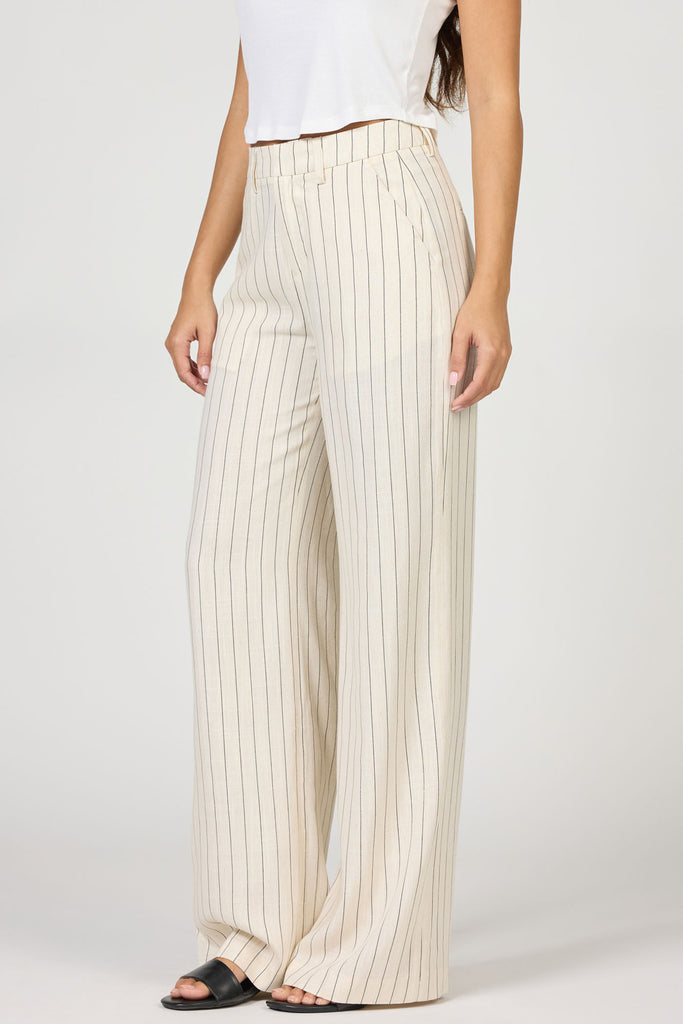 Person wearing white pinstripe pants on a plain background