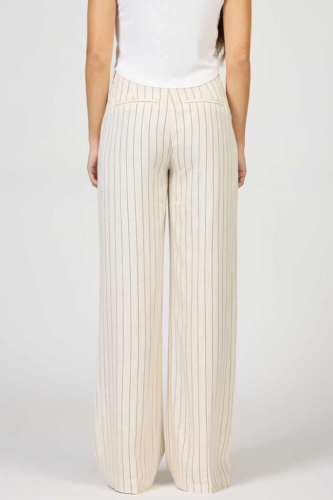Person wearing beige pleated pants on a white background