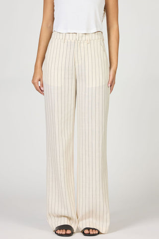 Person wearing white pleated pants on a plain background