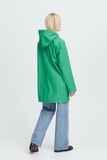 Person wearing a green raincoat and blue jeans on a white background