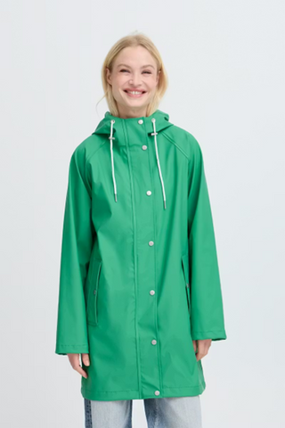 Woman wearing a green raincoat on a white background