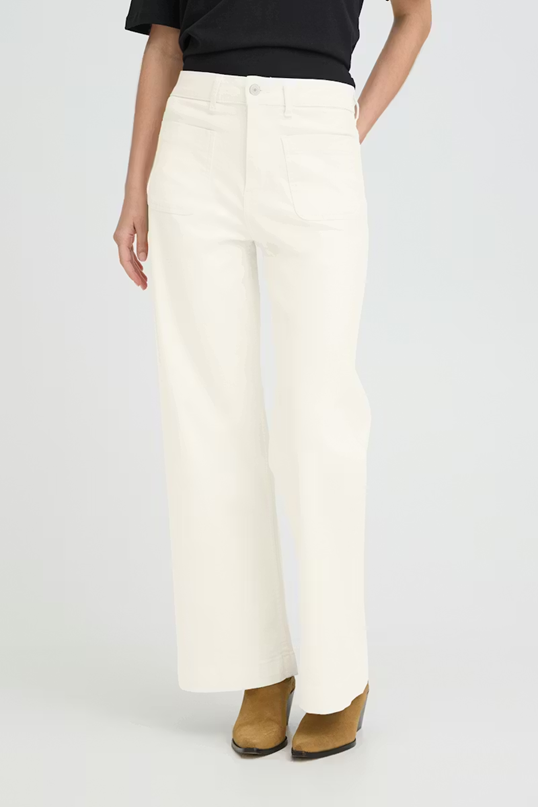 Person wearing white pants on a plain background