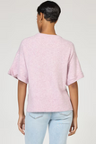 Person wearing a pink textured t-shirt and light blue jeans on a plain background