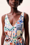 Woman wearing a colorful patterned dress against a plain background