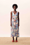 Woman wearing a colorful floral dress against a plain background