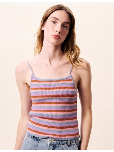 Woman wearing a colorful striped tank top against a plain background