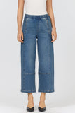 Person wearing blue denim wide-leg pants on a white background