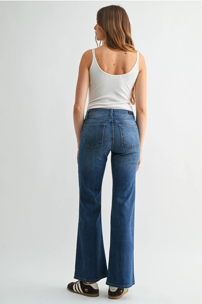back of woman in flare jeans and white tank top