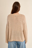 Woman wearing a beige knitted sweater and blue jeans on a beige background
