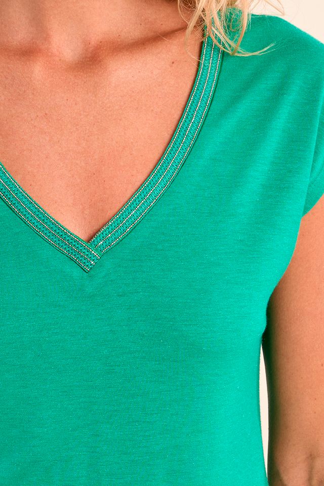 Close-up of a green V-neck shirt with a blurred background