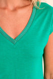 Close-up of a green V-neck shirt with a blurred background