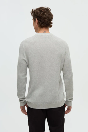 Person wearing a gray sweater on a white background