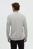 Person wearing a gray sweater on a white background