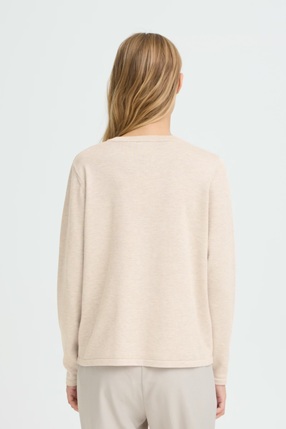 Woman wearing a beige sweater on a white background