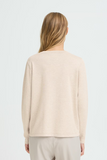 Woman wearing a beige sweater on a white background