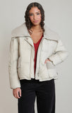 woman in cream puffer coat against white background