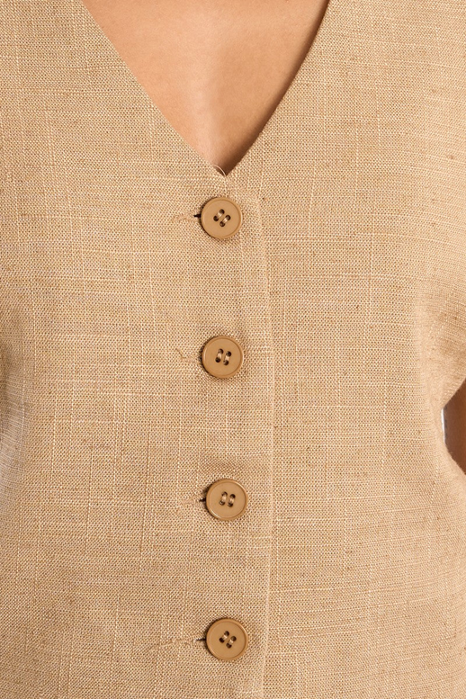 Close-up of a beige shirt with wooden buttons on a beige background