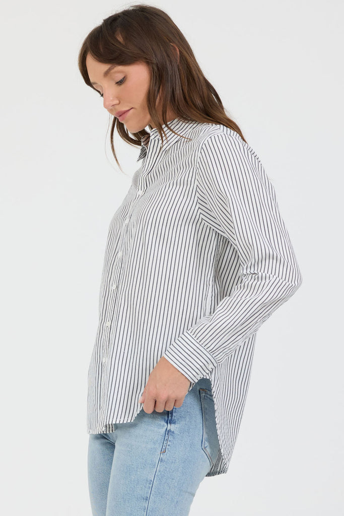 Woman wearing a striped shirt and jeans on a white background