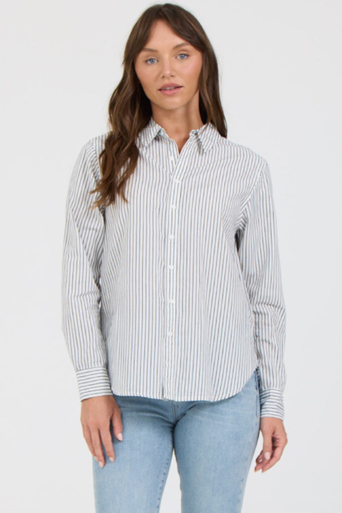 Woman wearing a striped shirt and jeans on a white background