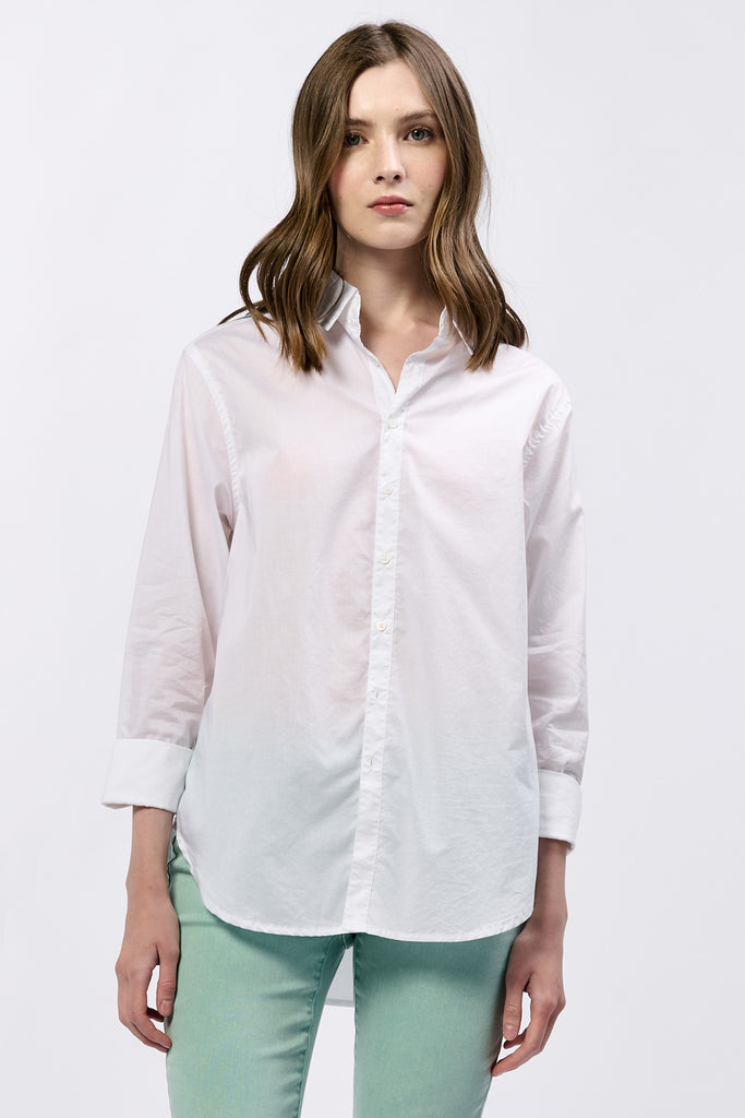 Person wearing a white button-up shirt and light green pants on a white background