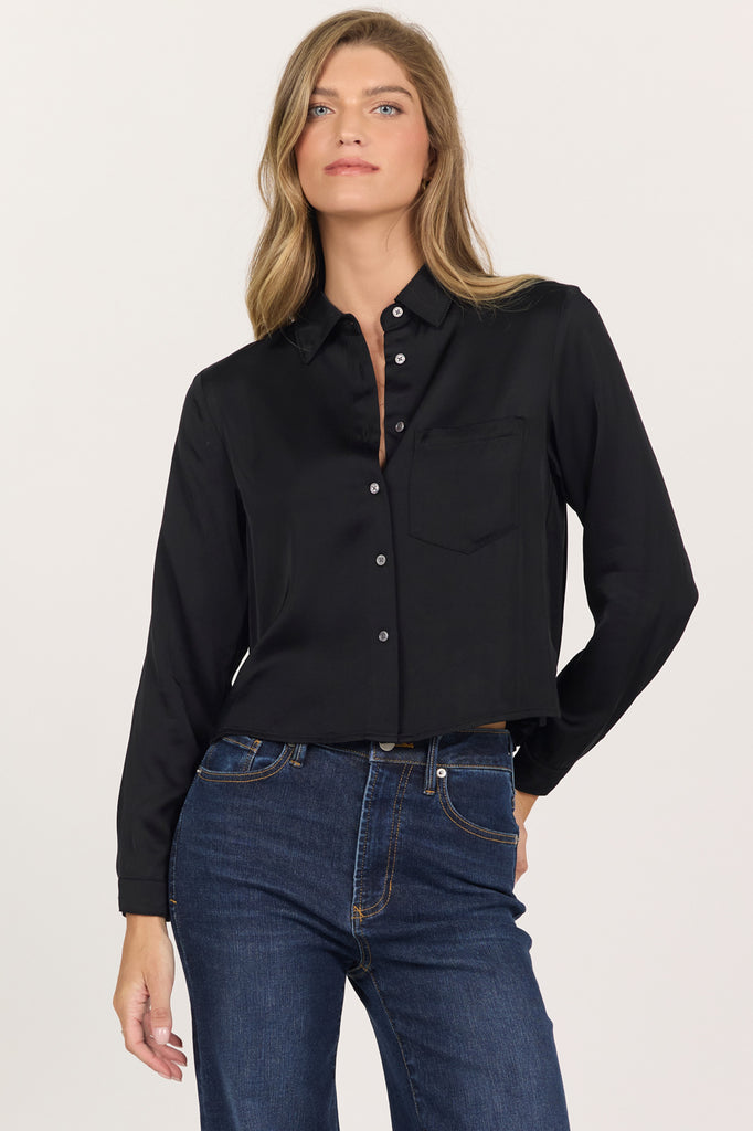 woman in black, cropped button up blouse and jeans