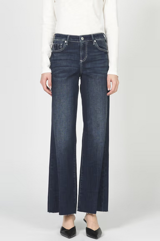 Person wearing dark blue jeans on a white background