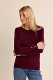 woman in plum sweater against white background