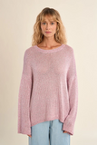 Woman wearing a pink knitted sweater against a beige background