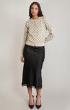 woman in black midi skirt with lace detail at the bottom and polkadot sweater