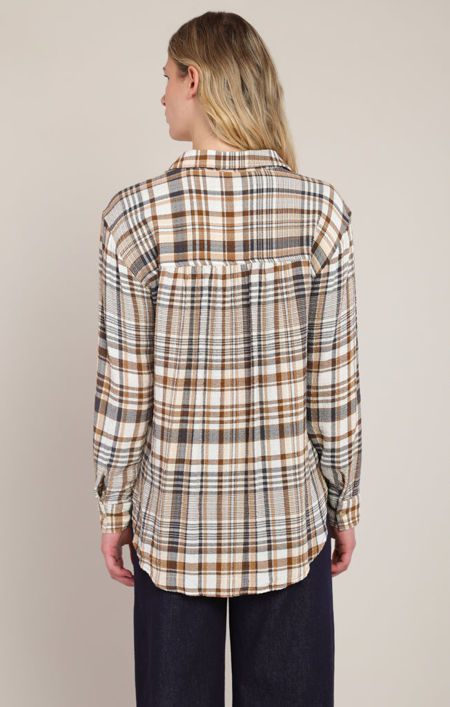 back of woman in plaid shirt and jeans with white background
