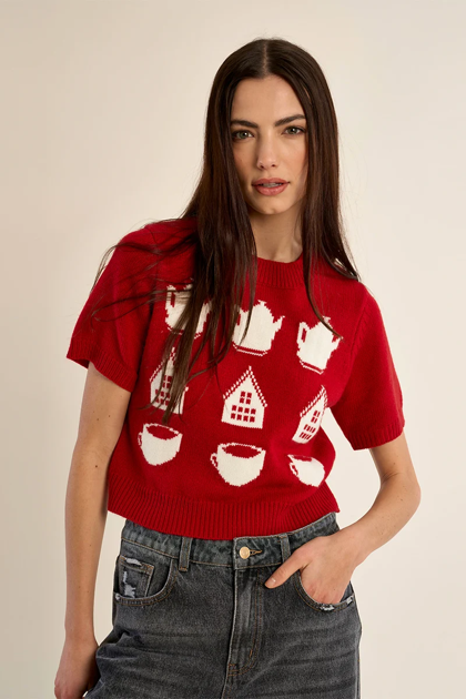 woman in red, patterned sweater against white background