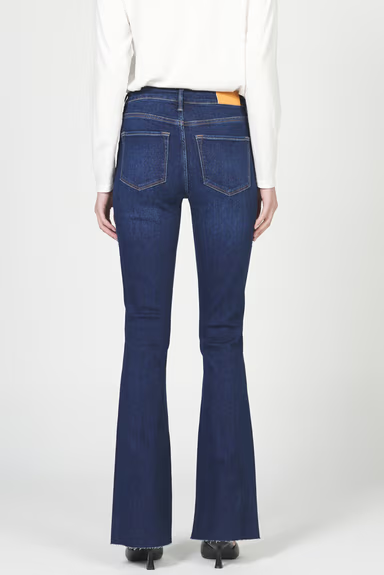 Blue flared jeans worn by a person on a white background