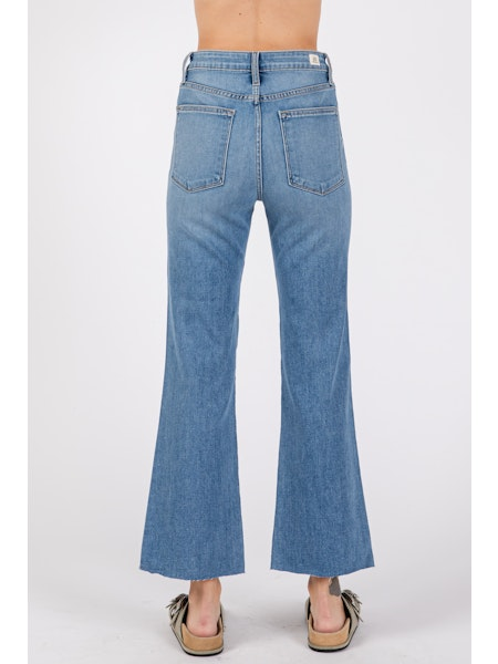 Blue flared jeans worn by a person on a white background