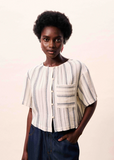 Woman wearing a patterned blouse against a plain background